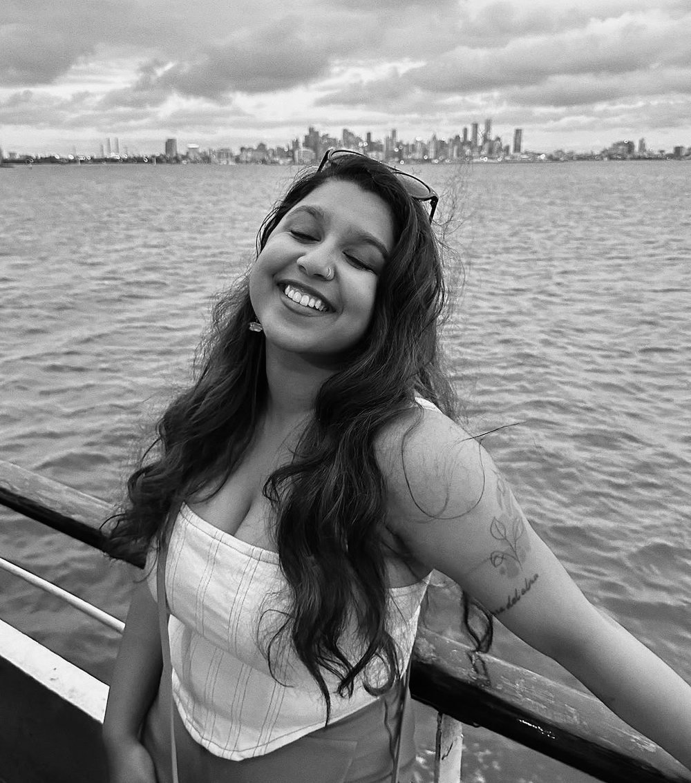 Portrait of the volume's writer, smiling on a boat with a city skyline behind
